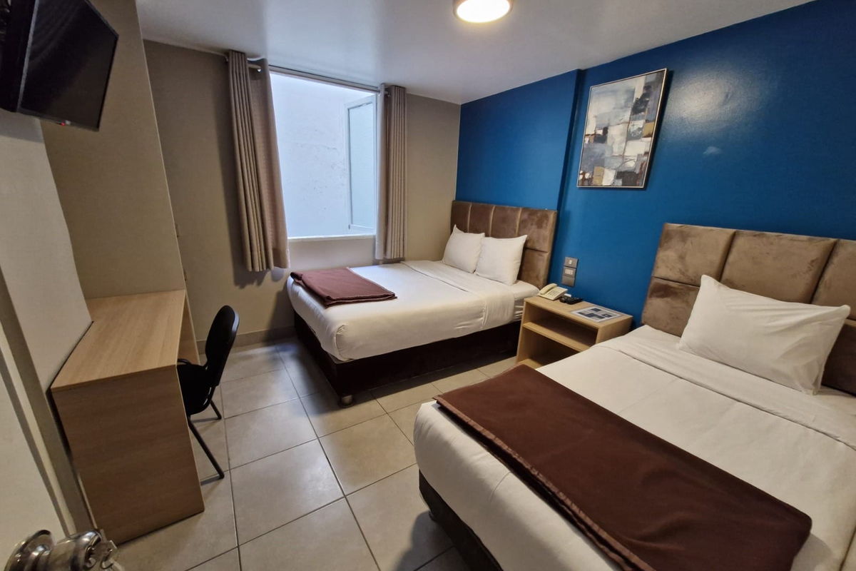 Habitación Doble del Hotel Residencial Alfa, con dos camas y escritorio