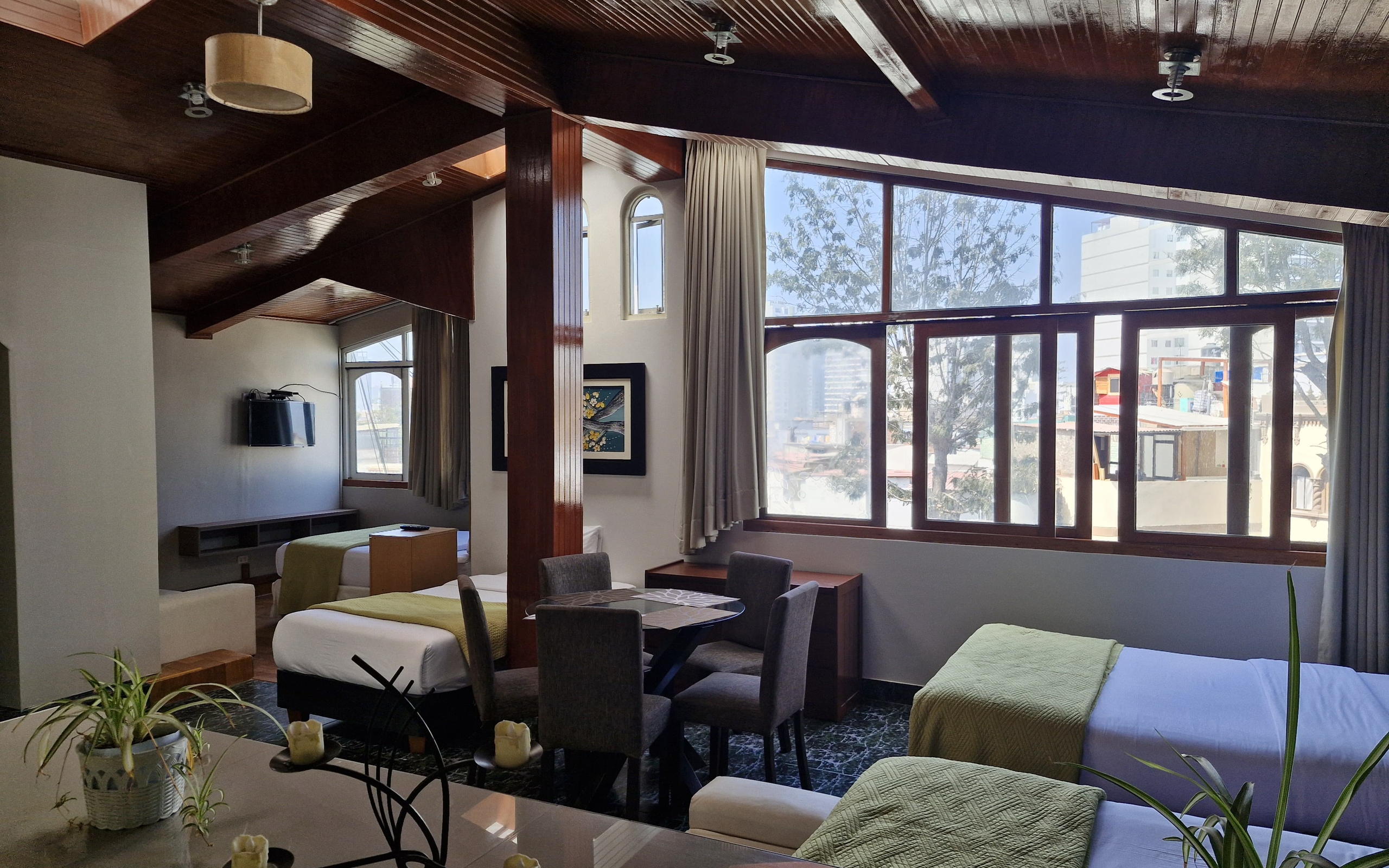 Habitación familiar del Hotel Residencial Alfa, con ventanales y comedor