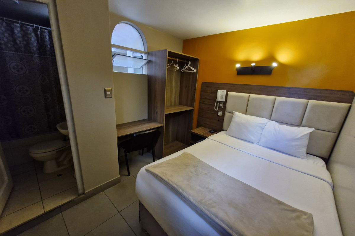 Habitación Individual del Hotel Residencial Alfa, con cama, escritorio y baño propio