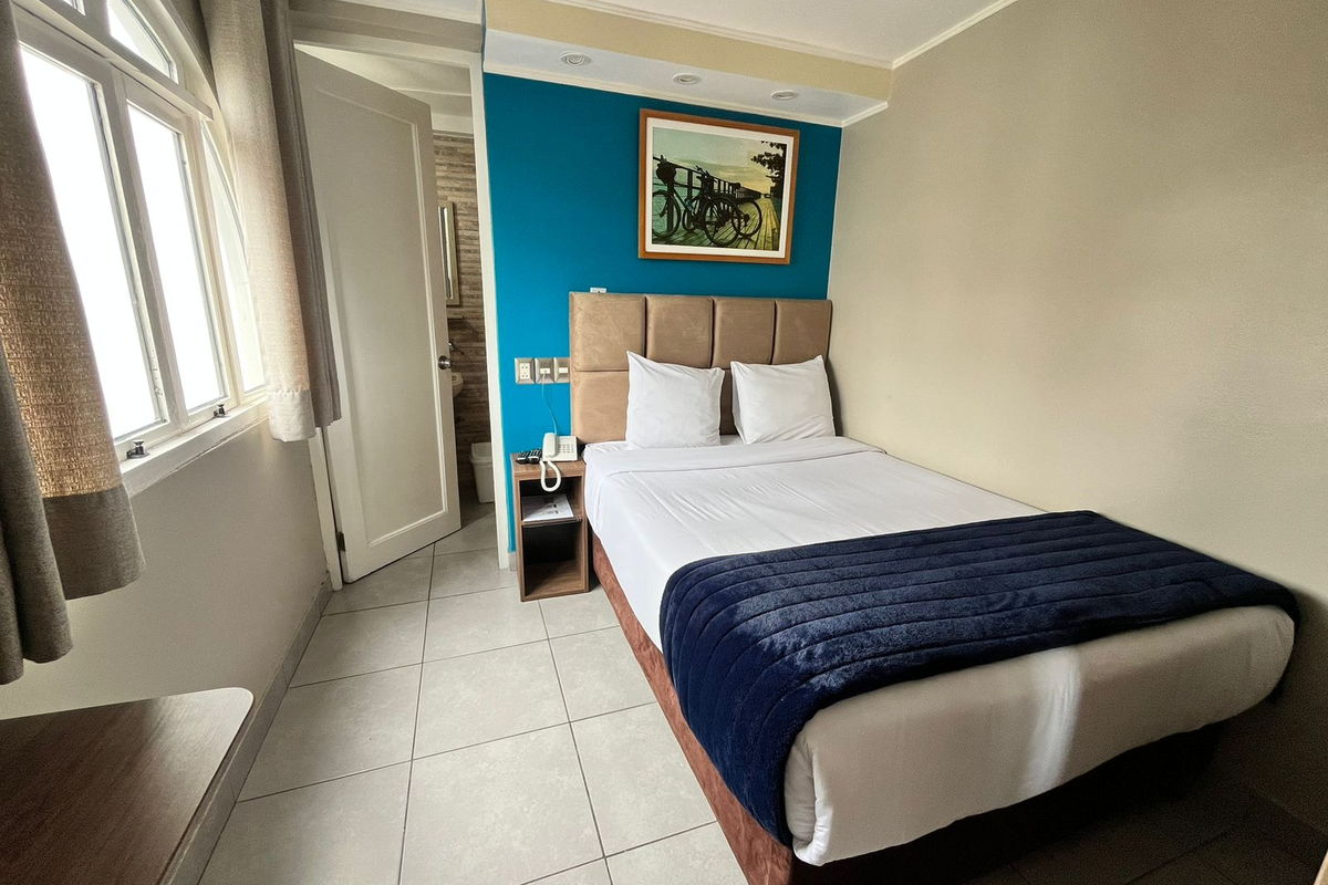 Habitación Matrimonial del Hotel Residencial Alfa, con cama de dos plazas y ventana